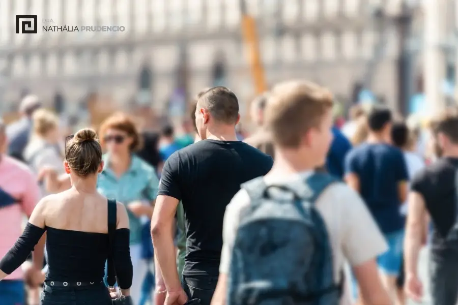 Multidão caminhando na rua em dia claro - 2,5 bilhões de pessoas podem ter perda auditiva, até 2050.